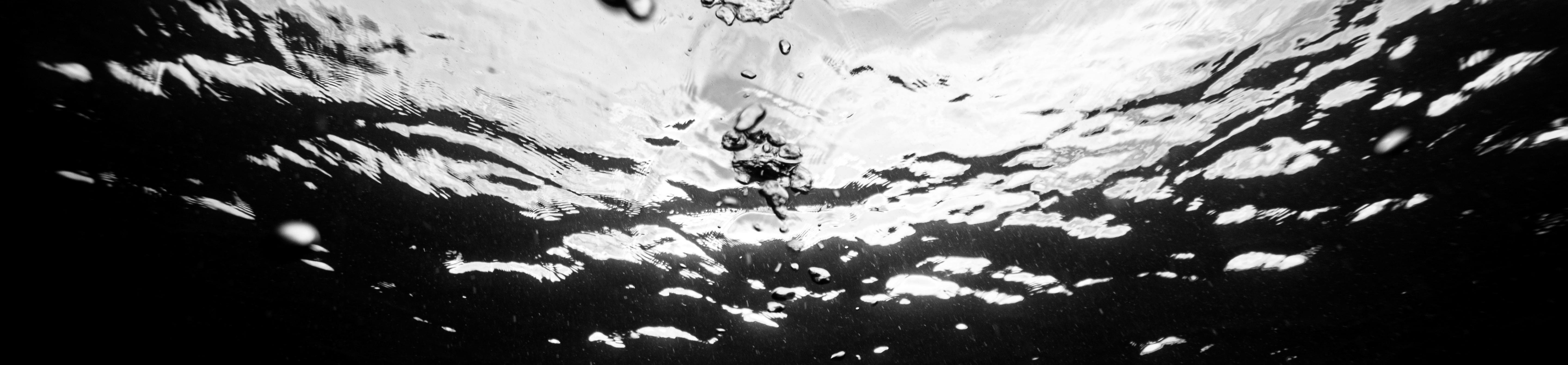 Greyscale image of underwater surface with some bubbles